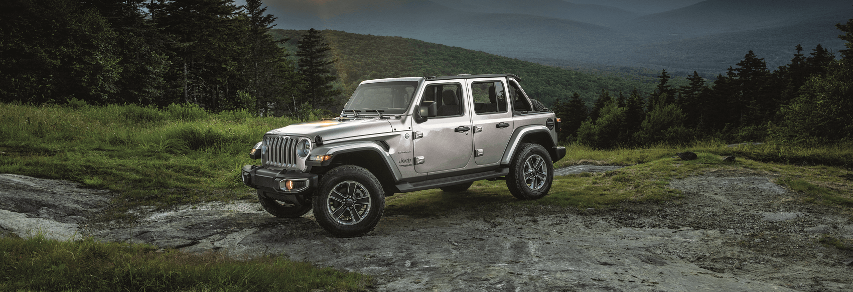 silver jeep gladiator parked on mountain dirt